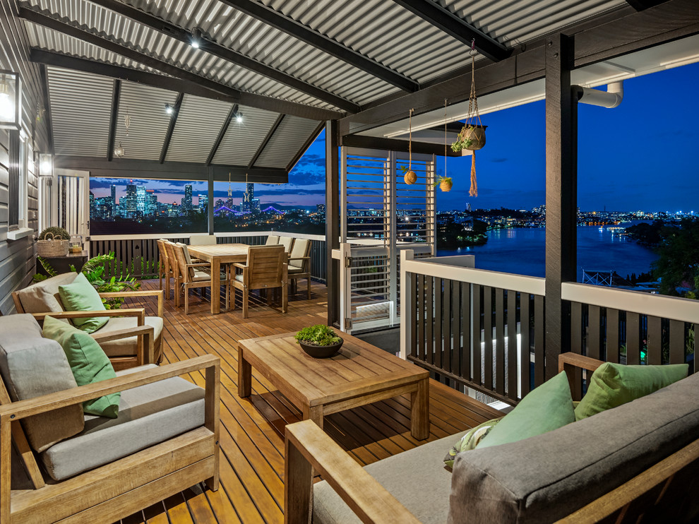 Inspiration for a large transitional backyard deck remodel in Brisbane with a roof extension