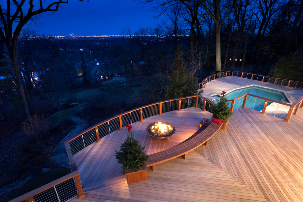 This is an example of a large contemporary back terrace in New York with a fire feature and no cover.