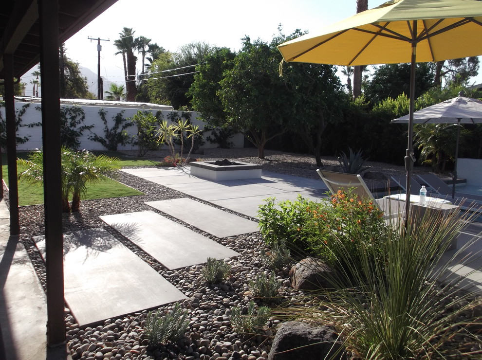 На фото: терраса среднего размера на заднем дворе в современном стиле с местом для костра без защиты от солнца
