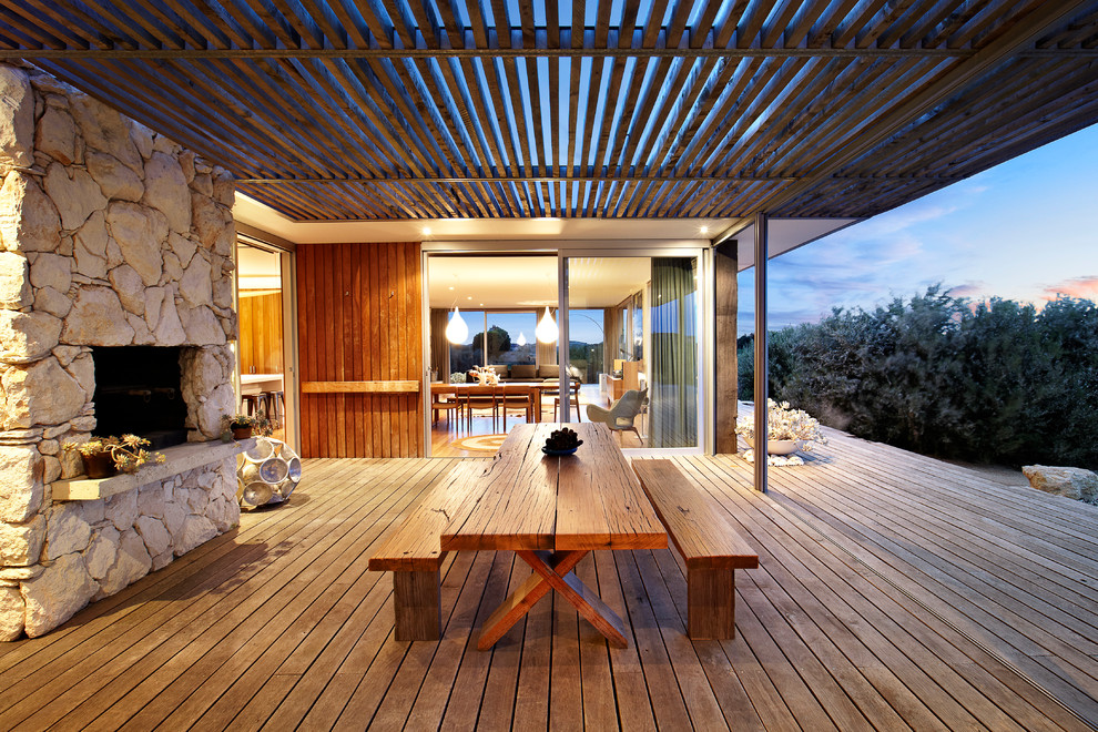 Aménagement d'une grande terrasse contemporaine avec un foyer extérieur et une extension de toiture.