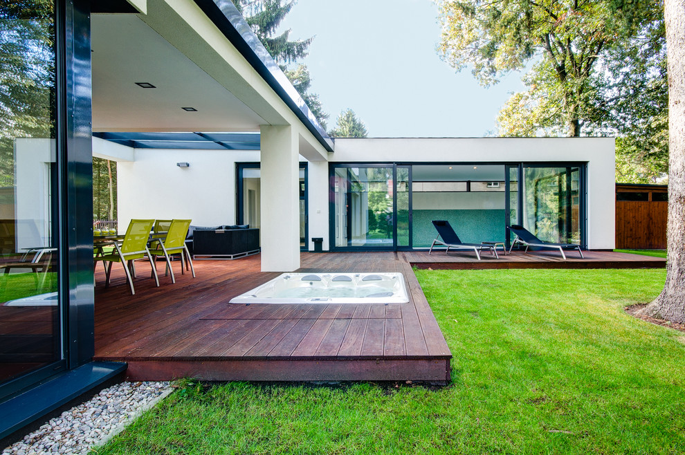 Foto di una grande terrazza minimalista dietro casa con un tetto a sbalzo
