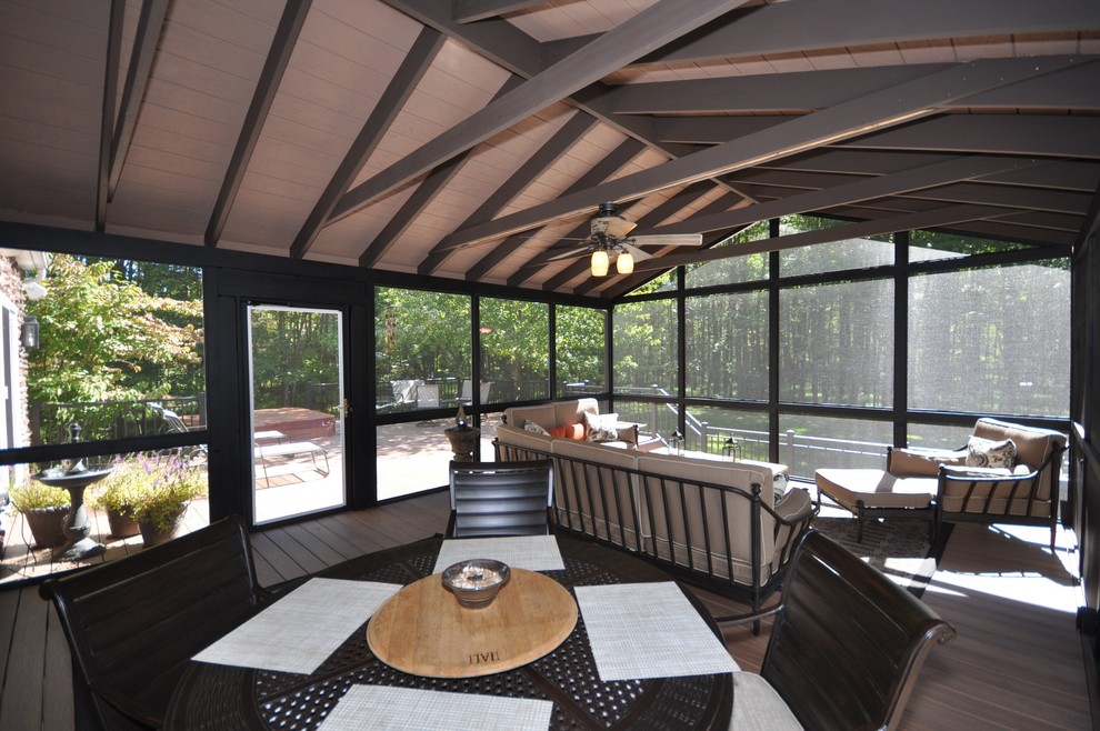 Example of a large classic backyard deck design in New York with a roof extension