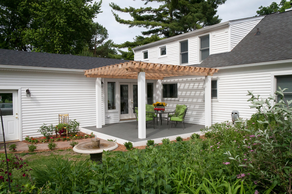 Diseño de terraza campestre de tamaño medio en patio trasero con pérgola