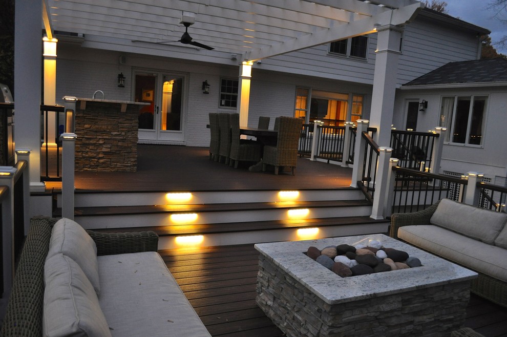 Modelo de terraza tradicional grande en patio trasero con cocina exterior y pérgola