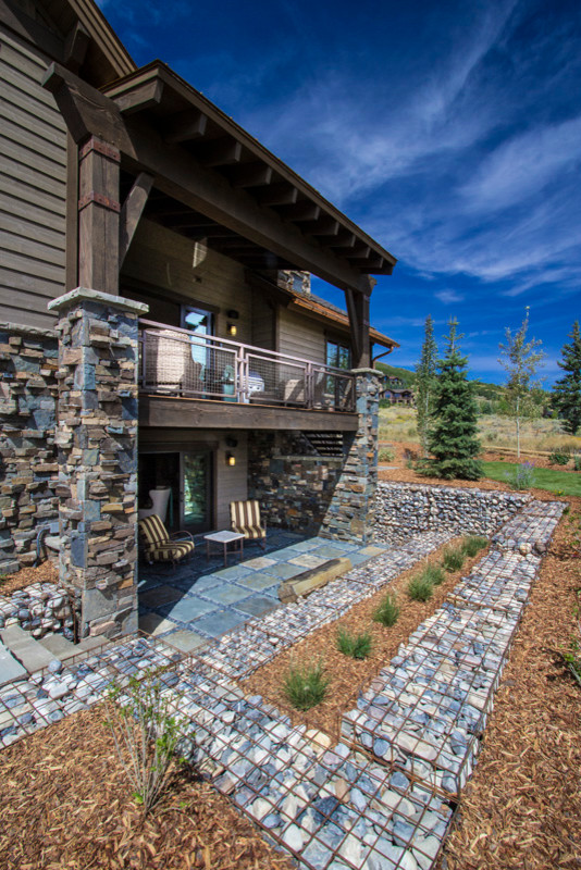 Inspiration for a large rustic backyard deck remodel in Salt Lake City with a roof extension
