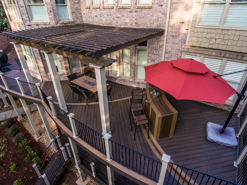 Modelo de terraza de estilo americano grande en patio trasero con cocina exterior y pérgola