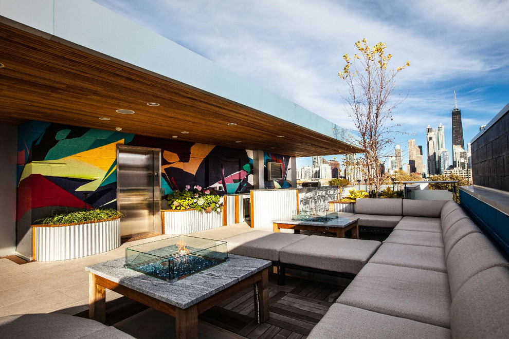 Inspiration for a mid-sized contemporary rooftop deck remodel in Chicago with a fire pit and a roof extension