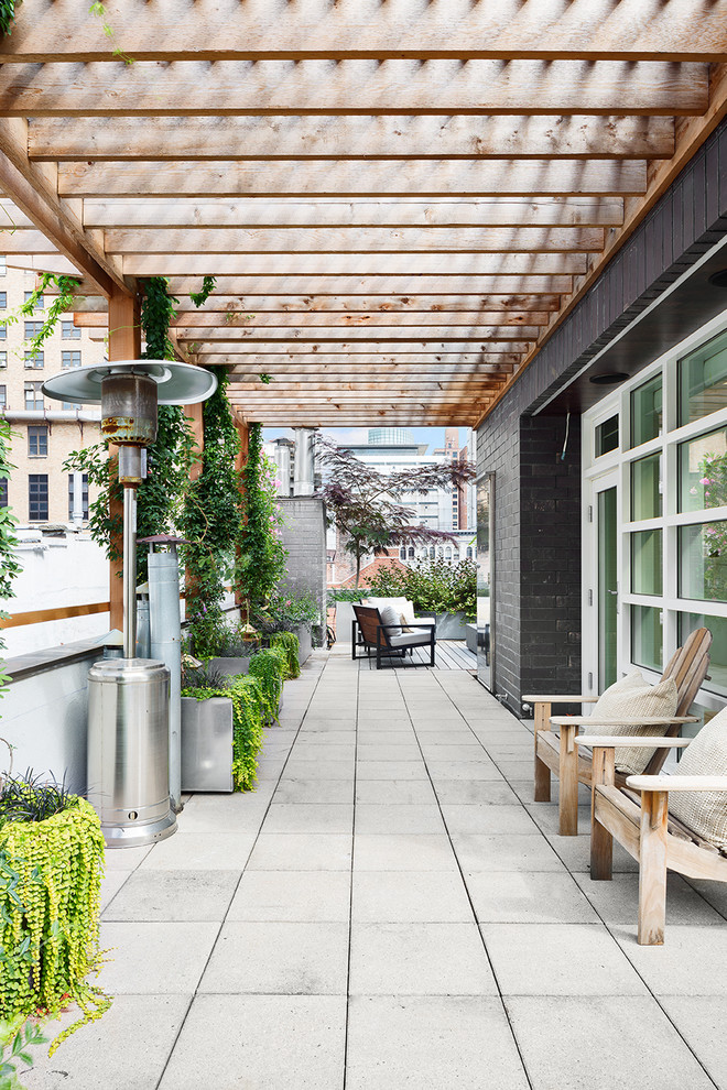 Large minimalist rooftop deck photo in New York with a fire pit and a pergola