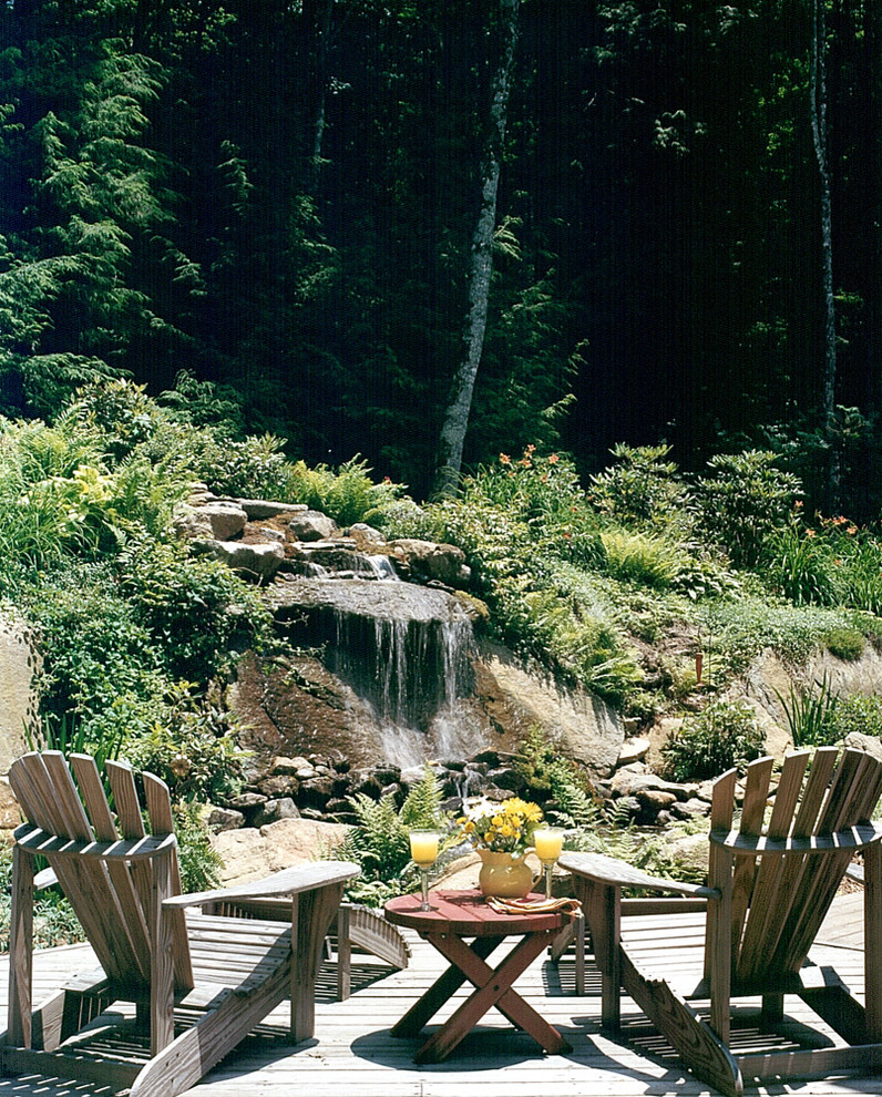 Photo of a large rustic back terrace in Charlotte with a water feature and no cover.