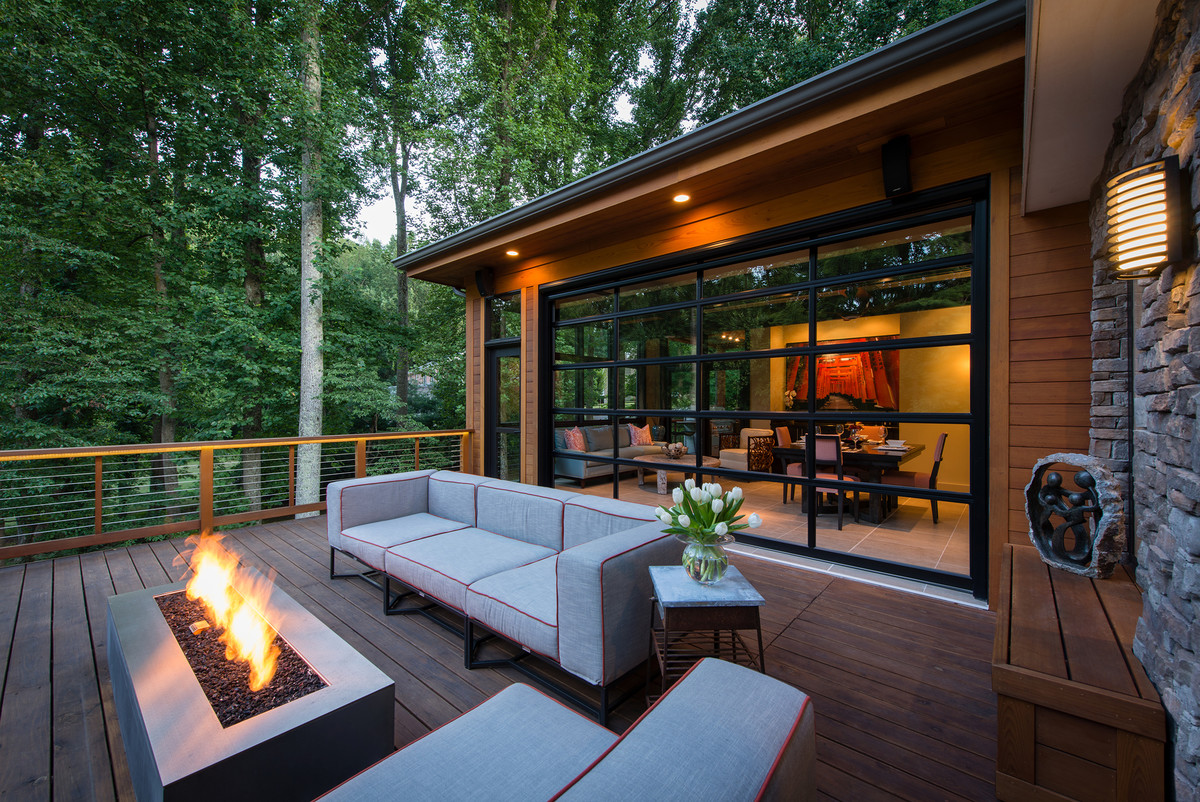 Mid-sized transitional backyard deck photo in DC Metro with a fire pit and a roof extension