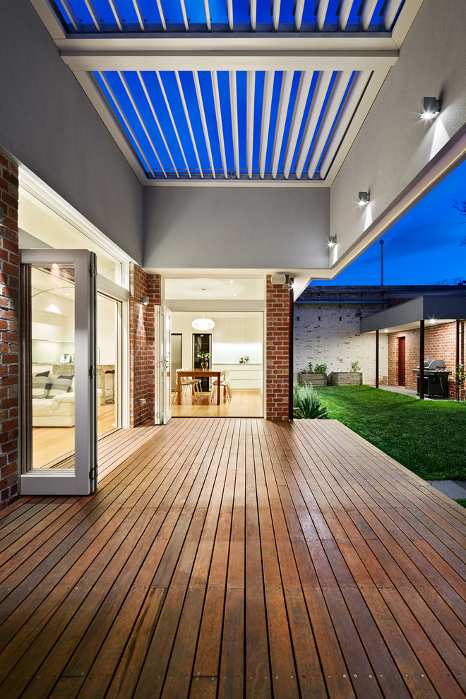 Diseño de terraza contemporánea de tamaño medio en patio trasero con toldo