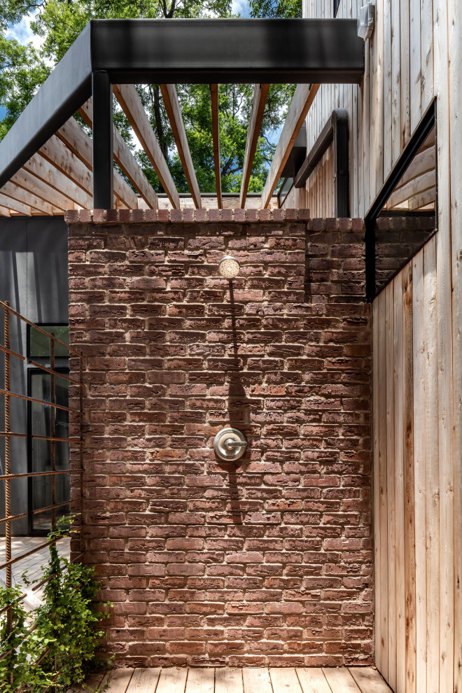 Cette image montre une terrasse avec une douche extérieure design avec une pergola.