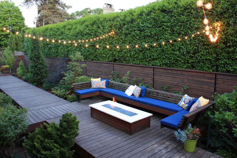 Mid-sized trendy backyard deck photo in Other with a fire pit