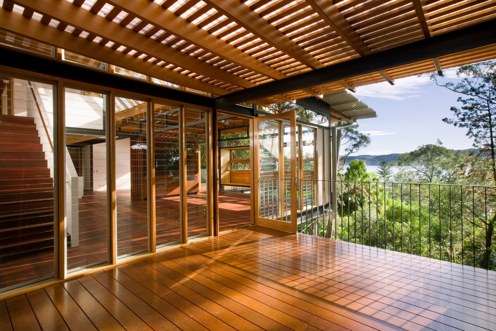 Example of a mid-sized trendy deck design in Sydney with a roof extension