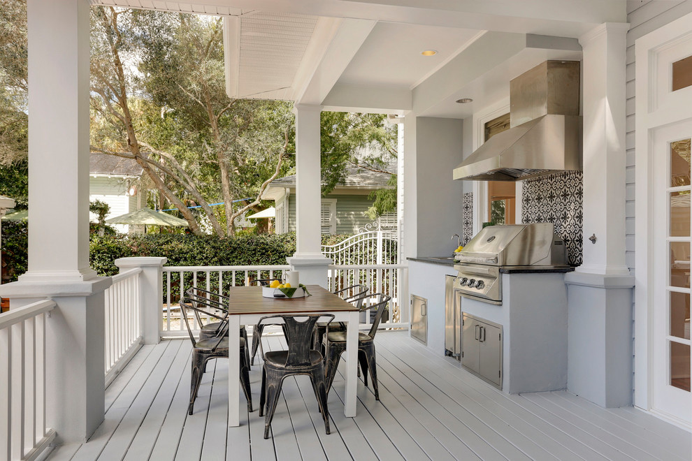 Cette photo montre une grande terrasse arrière chic avec une cuisine d'été et une extension de toiture.