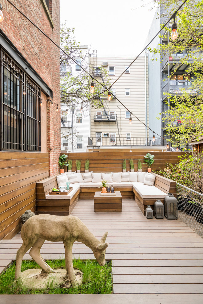Medium sized eclectic back terrace in New York with a fire feature and no cover.
