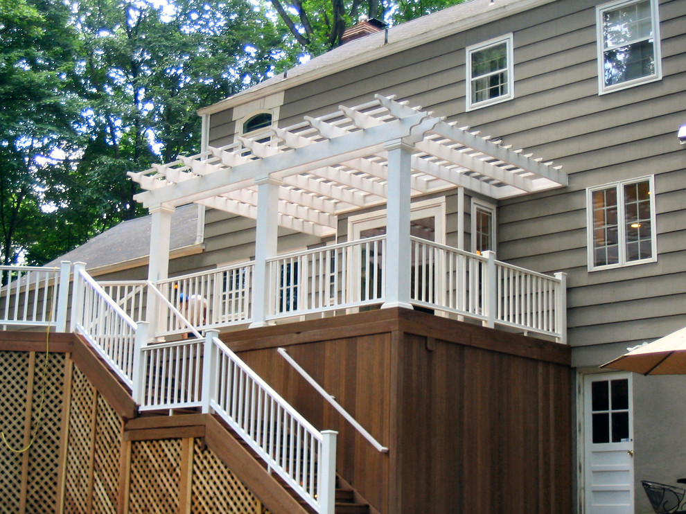 Large elegant backyard deck skirting photo in New York with a pergola