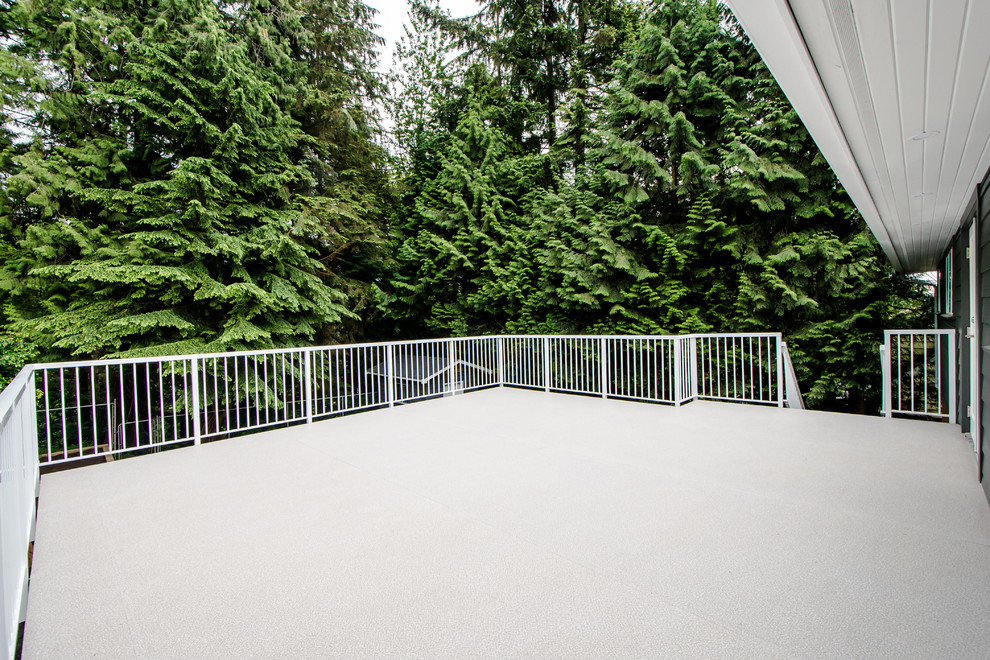 Large trendy backyard deck photo in Vancouver with a roof extension