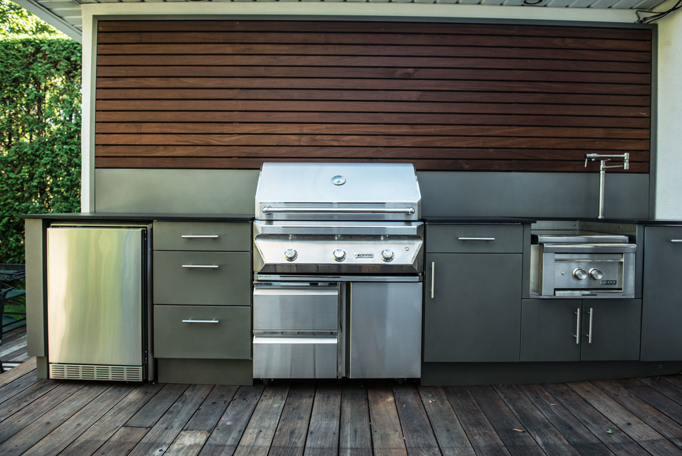 This is an example of a small industrial back terrace in Montreal with an outdoor kitchen and no cover.