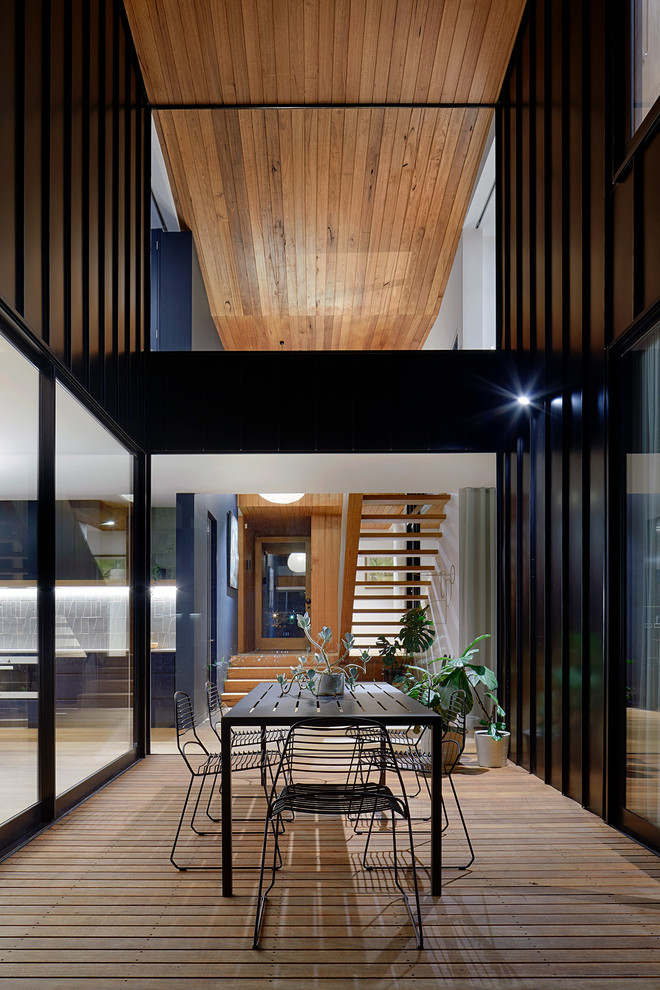 Photo of a large modern back terrace in Melbourne with a roof extension.