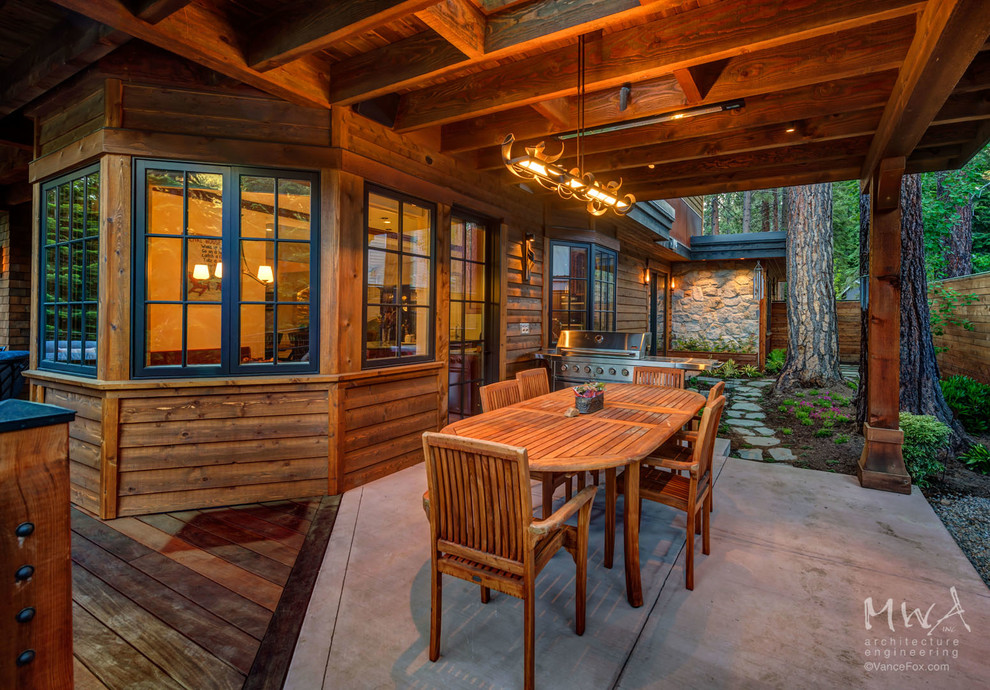 Cette photo montre une terrasse arrière chic de taille moyenne avec une cuisine d'été et une extension de toiture.