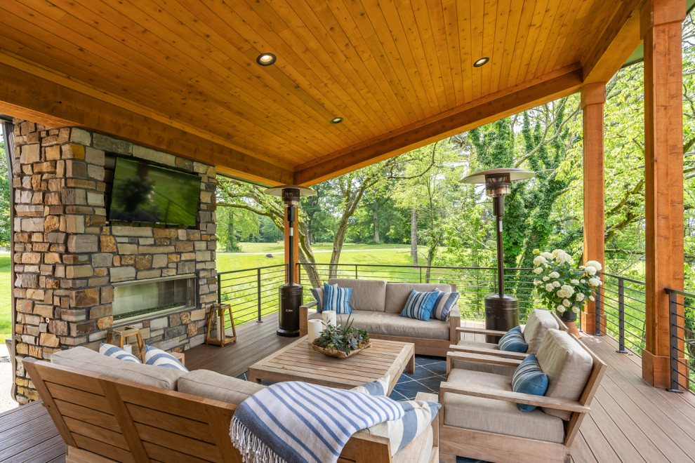 Inspiration for a rustic deck remodel in Cincinnati with a fireplace and a roof extension