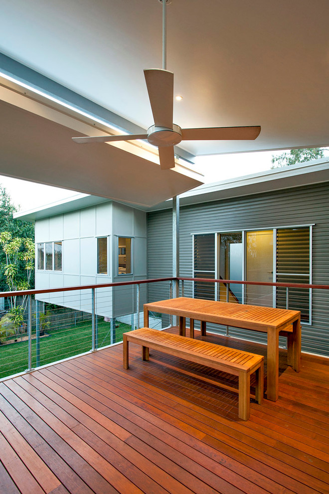 Idée de décoration pour une grande terrasse arrière tradition avec une extension de toiture.