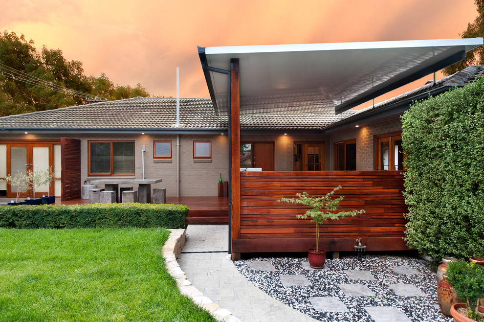 Foto di una piccola terrazza design dietro casa con un tetto a sbalzo