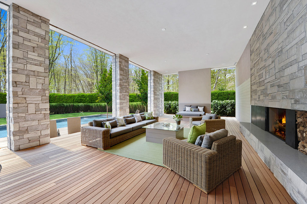 Cette image montre une terrasse design avec un foyer extérieur.