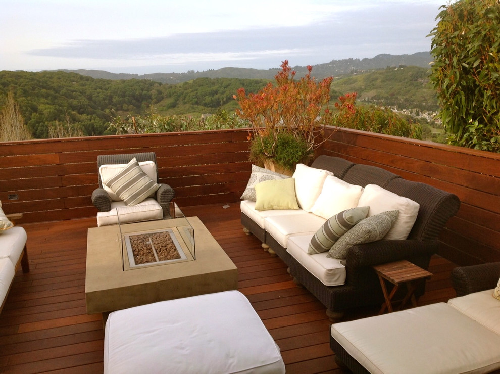 Idée de décoration pour une terrasse arrière minimaliste de taille moyenne avec un foyer extérieur et un auvent.