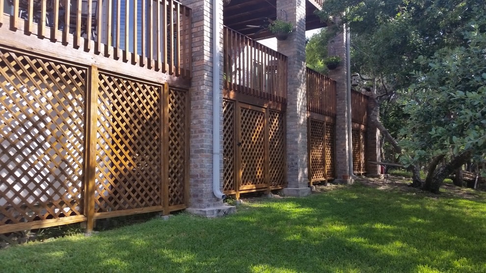 Example of a large classic backyard deck design in Austin with a roof extension