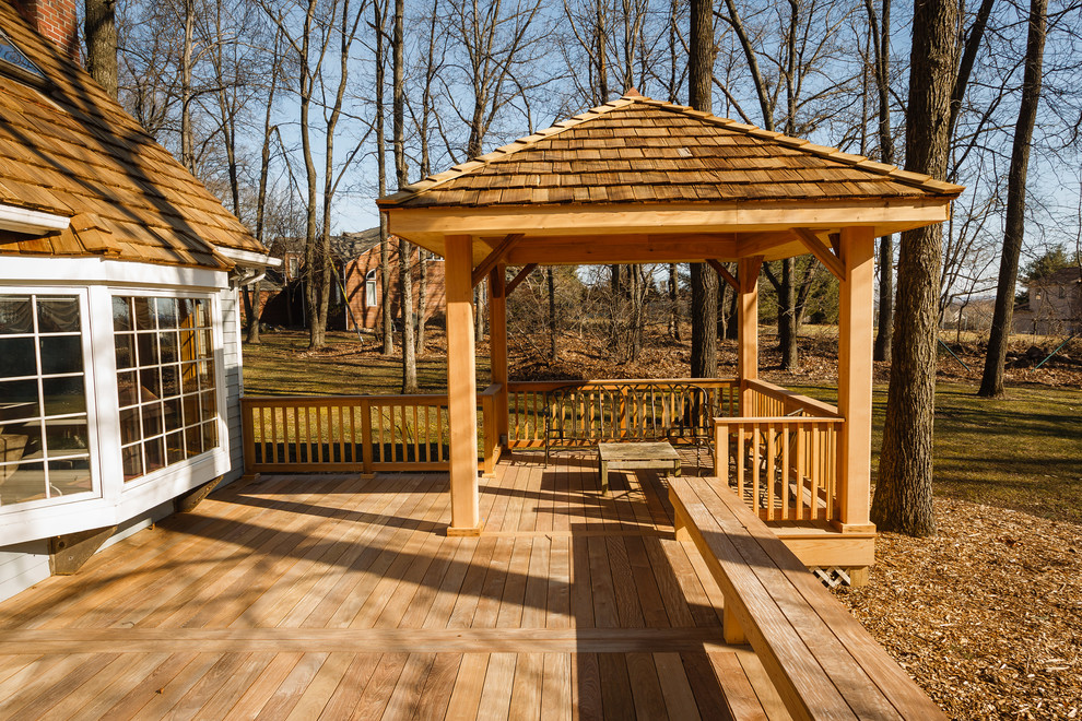 Large elegant backyard deck photo in Other with a pergola