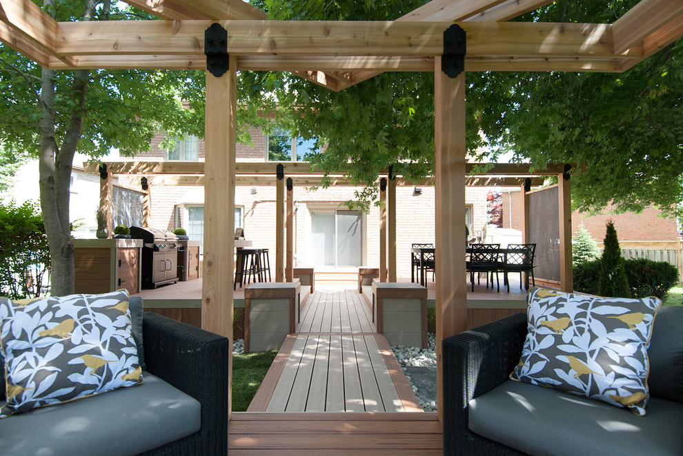 Design ideas for a medium sized rustic back terrace in Toronto with an outdoor kitchen and a pergola.