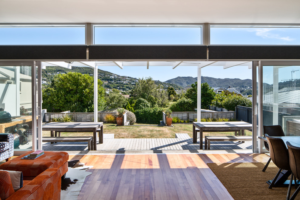 This is an example of a contemporary back terrace in Wellington with an outdoor kitchen and a pergola.