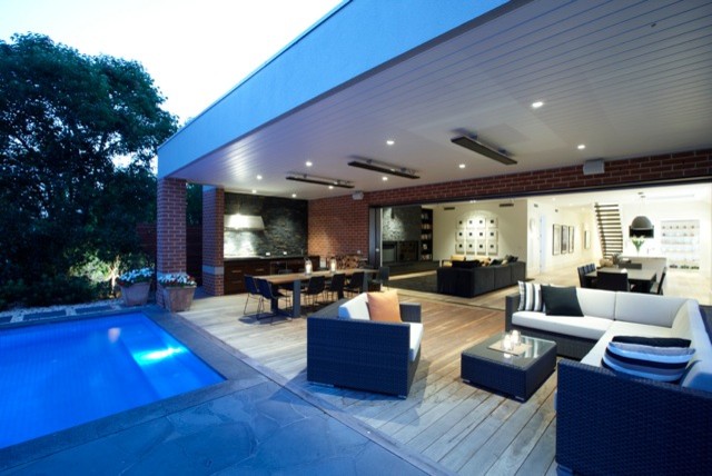 Ejemplo de terraza minimalista en anexo de casas con cocina exterior
