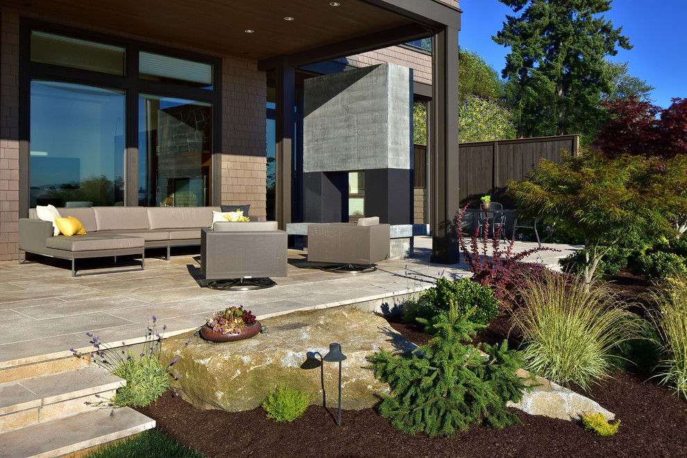 Deck - mid-sized contemporary backyard deck idea in Seattle with a fire pit and a roof extension