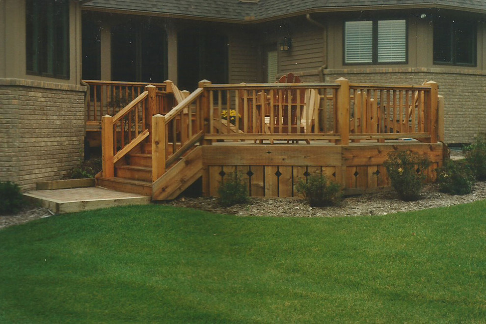 This is an example of a medium sized rustic back terrace in Detroit with no cover.