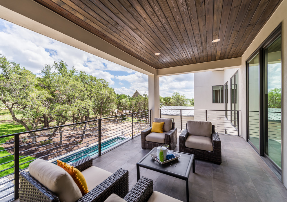 Photo of a large contemporary back terrace in Austin with a roof extension.