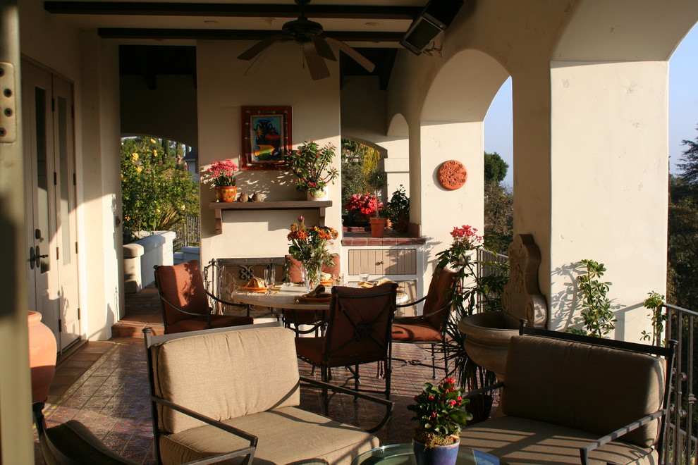 Large mediterranean side terrace in Orange County with a roof extension.