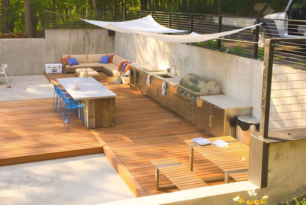 Foto de terraza actual de tamaño medio en patio trasero con cocina exterior y toldo