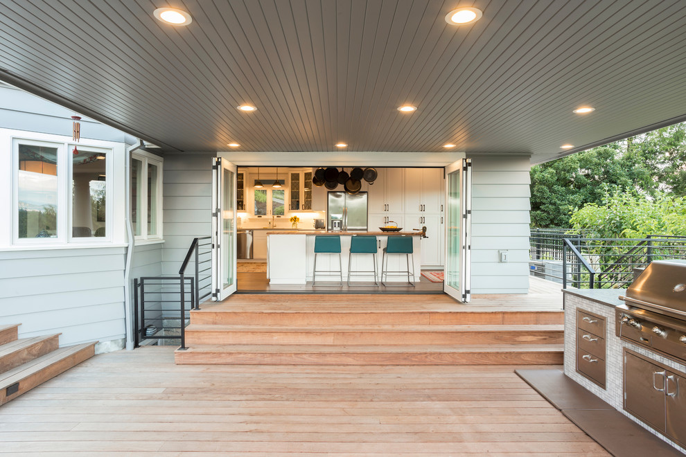 Idée de décoration pour une grande terrasse arrière tradition avec une cuisine d'été et une extension de toiture.