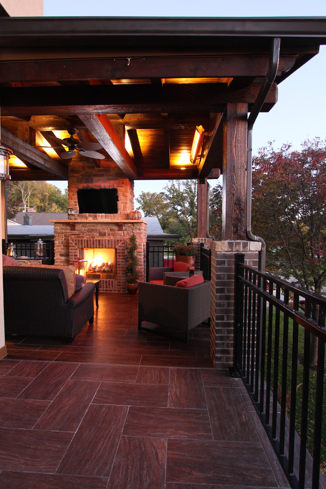 Inspiration for a large rustic backyard deck remodel in Kansas City with a fire pit and a roof extension