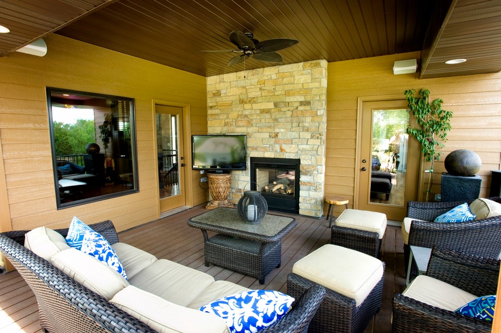 Inspiration for a contemporary backyard deck remodel in Omaha with a roof extension