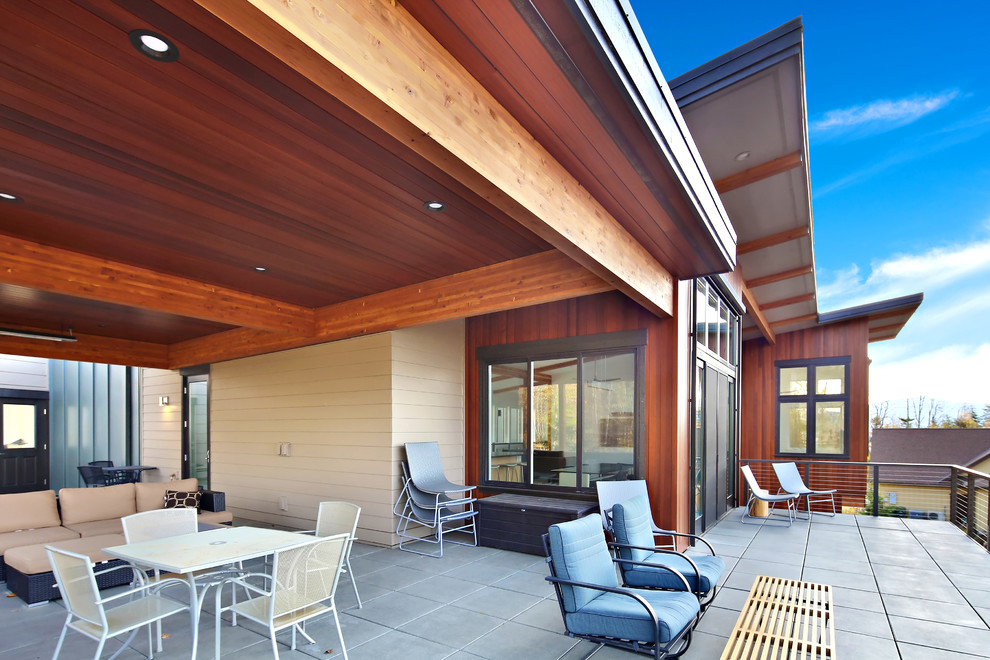 Design ideas for a large contemporary back terrace in Seattle with a roof extension.