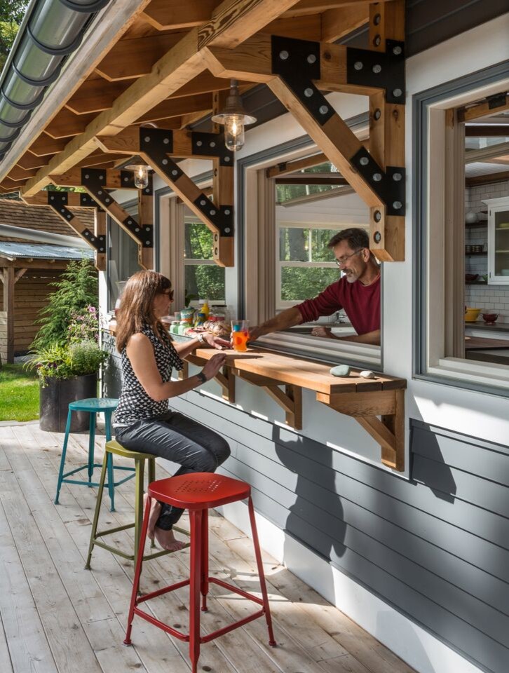 Aménagement d'une terrasse bord de mer avec une cuisine d'été et une extension de toiture.