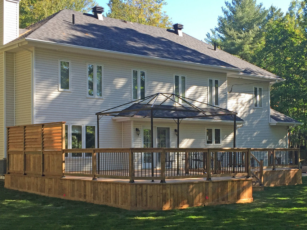 Large Brown Treated Wood Deck with Black Metal Spindle Railings