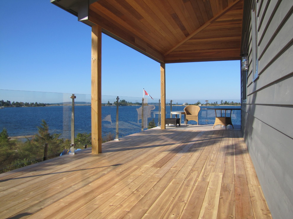 Réalisation d'une terrasse arrière marine de taille moyenne avec une extension de toiture.