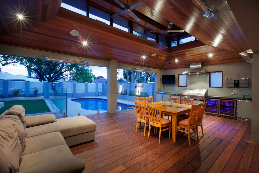 Idée de décoration pour une terrasse design avec une cuisine d'été et une extension de toiture.