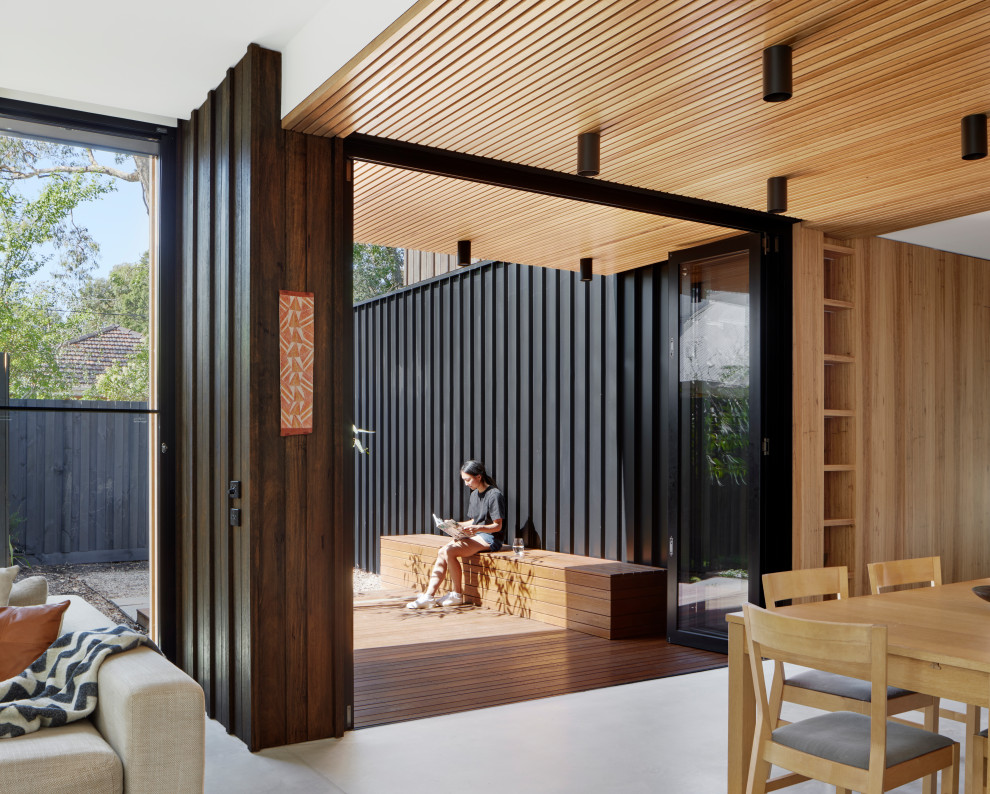 Medium sized contemporary side terrace in Melbourne with a roof extension.