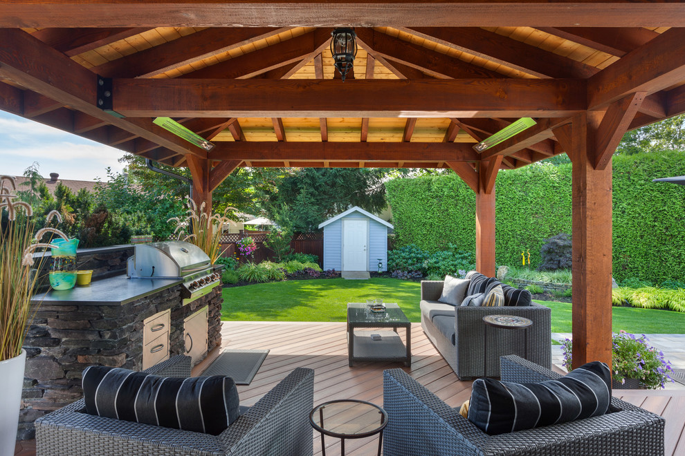 Expansive traditional back terrace in Vancouver with an outdoor kitchen and a roof extension.